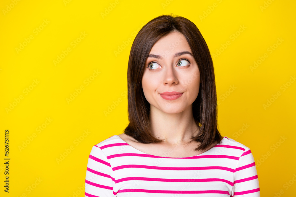 Closeup photo of young attractive cute girl smiling shy looking empty space isolated on yellow color background Closeup photo of young attractive cute girl smiling shy looking empty space isolated on yellow color background