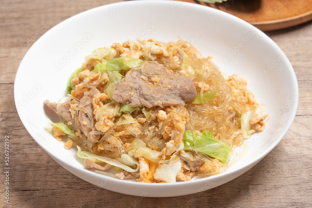 Stir fried vermicelli with pork, egg and collard greens in a white plate. Stir fried vermicelli with pork, egg and collard greens in a white plate.