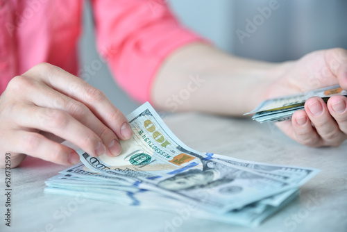 Woman counting dollars on table