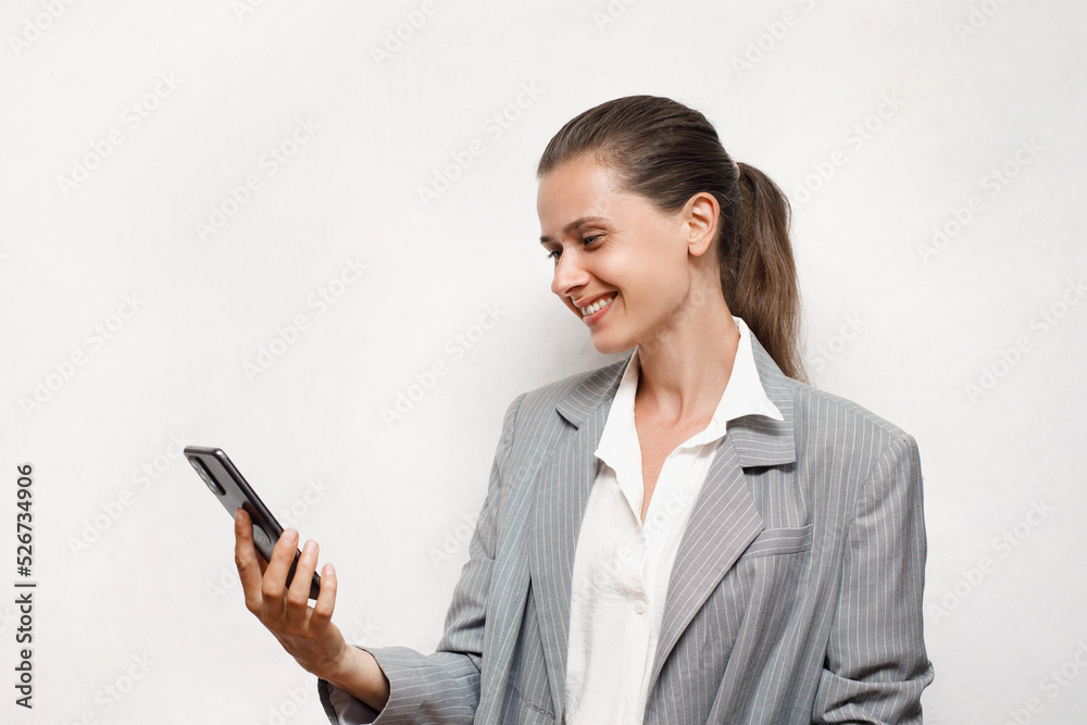 Successful female manager in a business suit is talking on a video link with a sincere smile, white background, communication Successful female manager in a business suit is talking on a video link with a sincere smile, white background, communication