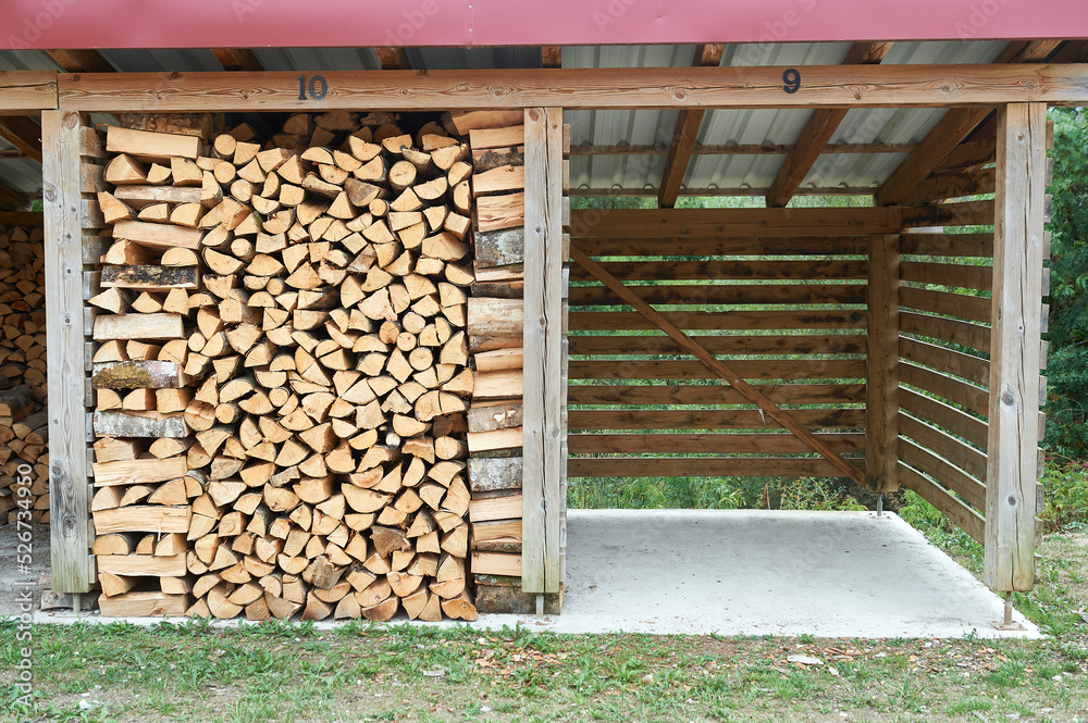 a wooden cabin filled with logs, blocks and wooden plugs for the domestic fire and another empty