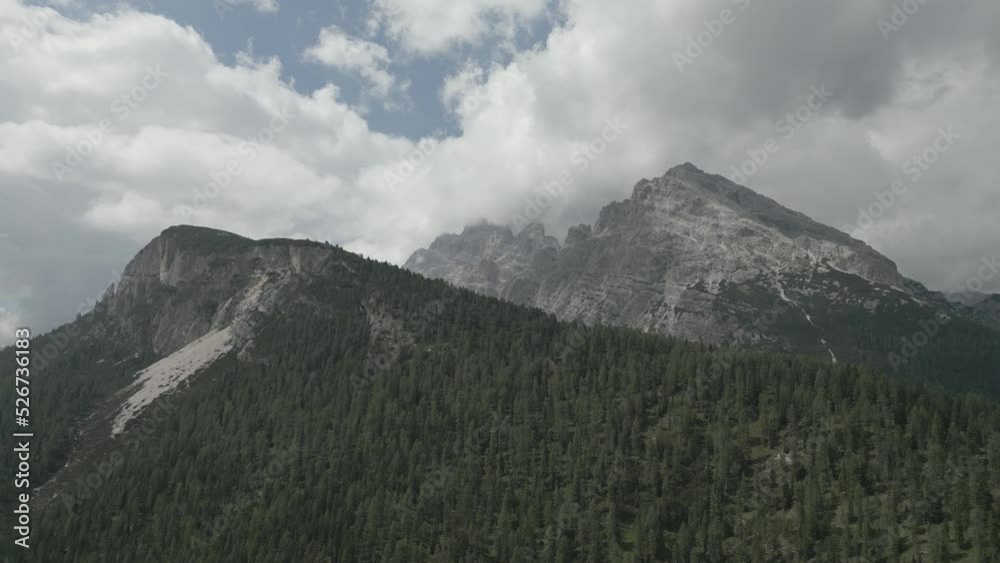 Flying over a Pine Forest with Mountain Peaks in the Background. Alpine Dolomites Drone Footage in 4K D-Cinelike Log format Flying over a Pine Forest with Mountain Peaks in the Background. Alpine Dolomites Drone Footage in 4K D-Cinelike Log format