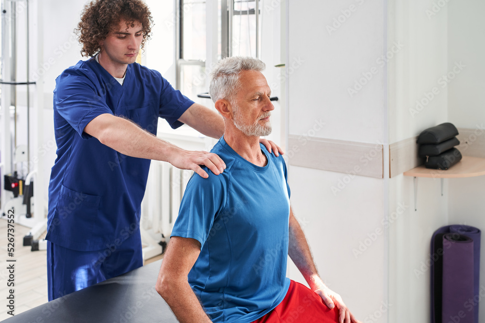 Obraz premium Young specialist working with his old patient at the hospital