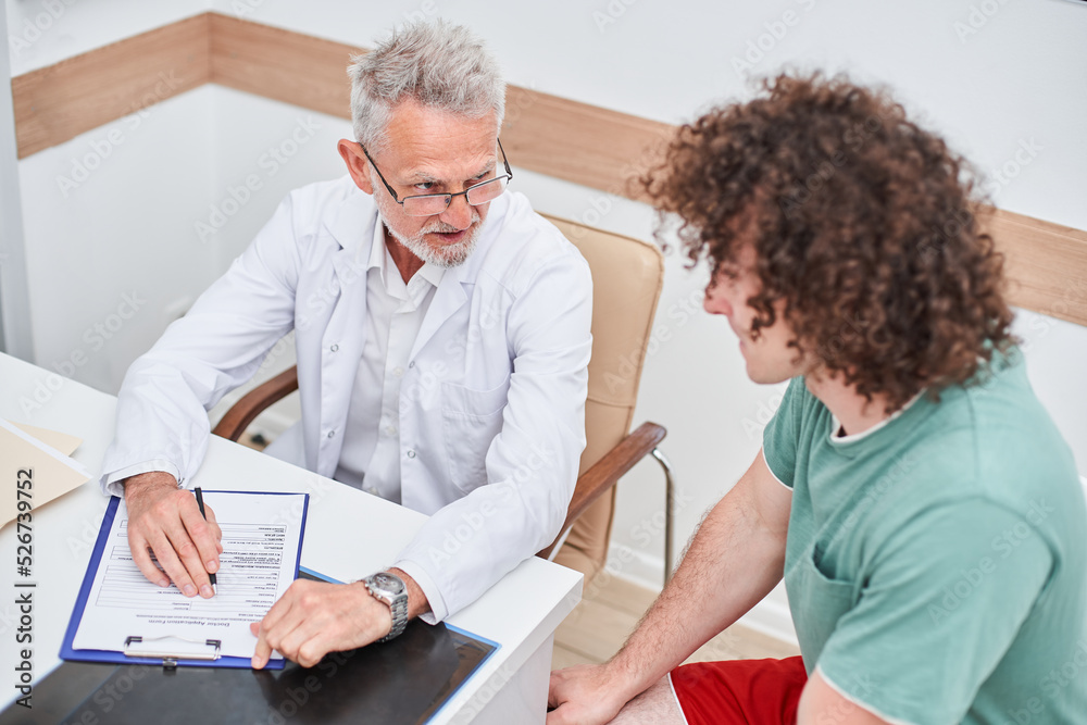 Patient attending checkup examination with senior doctor in office, talking about medicine Patient attending checkup examination with senior doctor in office, talking about medicine