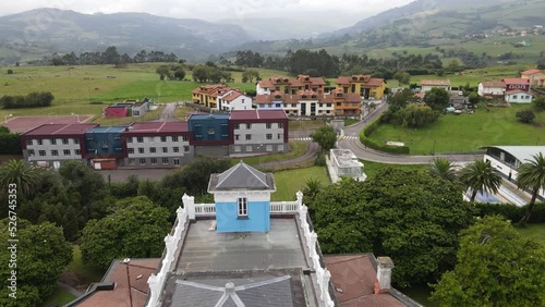 Aerial drone shot flying over the blue Museum of Emigration in the city of Colombres. photo