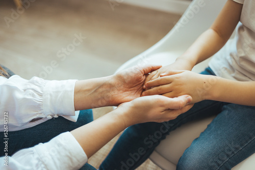 Fototapeta Naklejka Na Ścianę i Meble -  Close up image mother and daughter palms, mommy holding hands of kid, mom is always nearby, sharing mental and physical pain, concept of counsellor provides support help, heart-to-heart talk concept