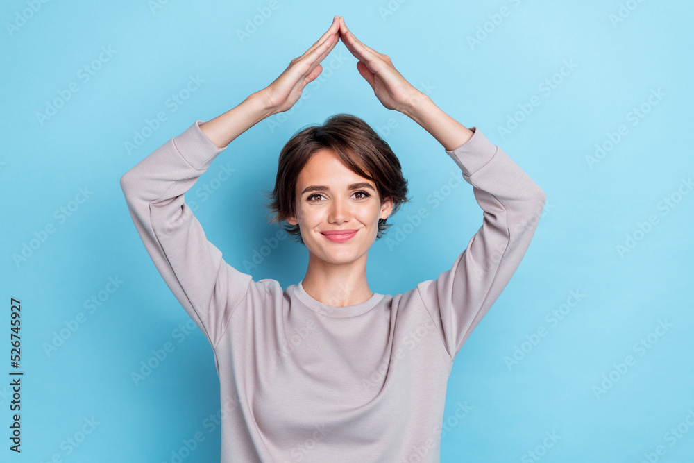 Photo of brown hairdo millennial lady arms roof wear grey sweatshirt isolated on blue color background Photo of brown hairdo millennial lady arms roof wear grey sweatshirt isolated on blue color background