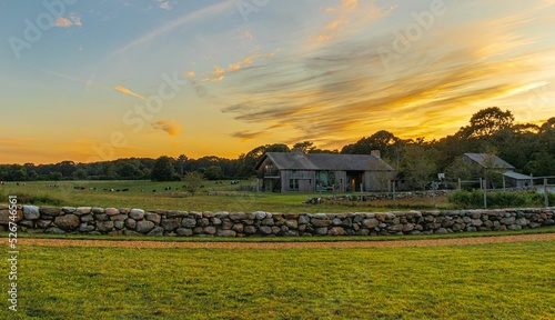 Fotografia Farmhouse in the field at sunset in Martha's vineyard, Massachusetts, USA