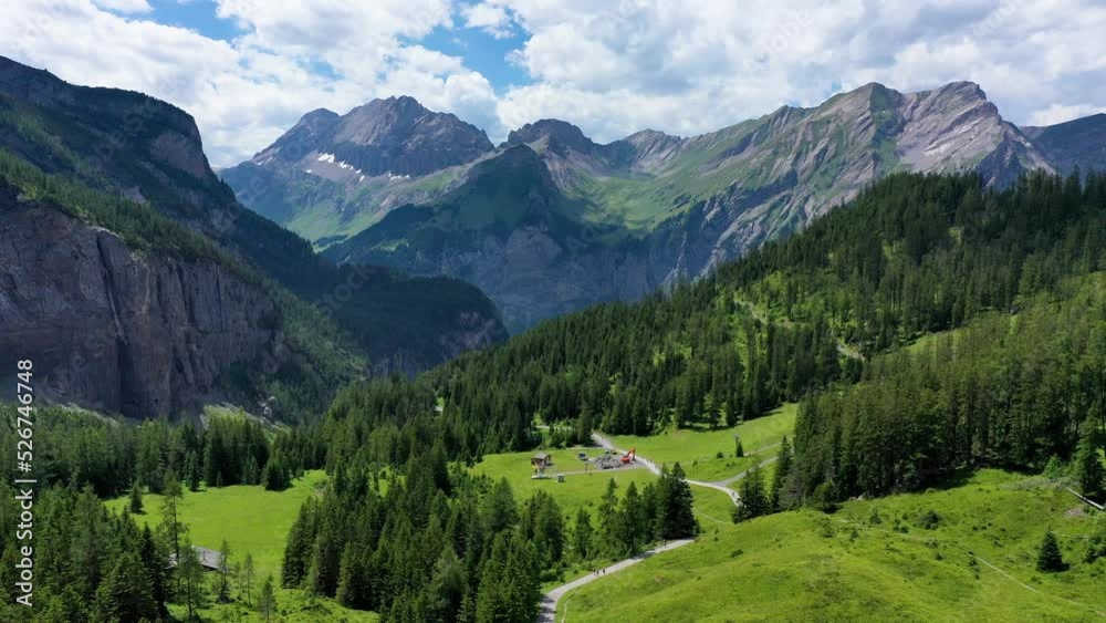 Famous Oeschinensee with Bluemlisalp mountain on a sunny summer day. Panorama of the azure lake Oeschinensee. Swiss alps, Kandersteg. Amazing tourquise Oeschinnensee with waterfalls, Switzerland. Famous Oeschinensee with Bluemlisalp mountain on a sunny summer day. Panorama of the azure lake Oeschinensee. Swiss alps, Kandersteg. Amazing tourquise Oeschinnensee with waterfalls, Switzerland.