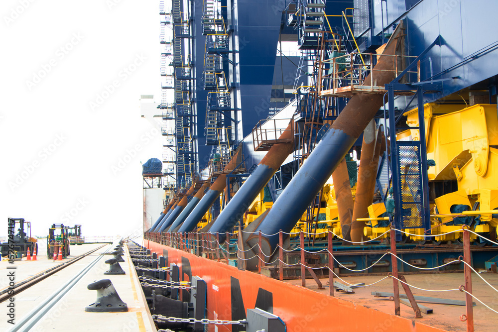 Large steel bar connects a container crane to a cargo ship to transport to a port in Thailand. Concept of transportation safety. It is an investment in business of container import-export terminals.