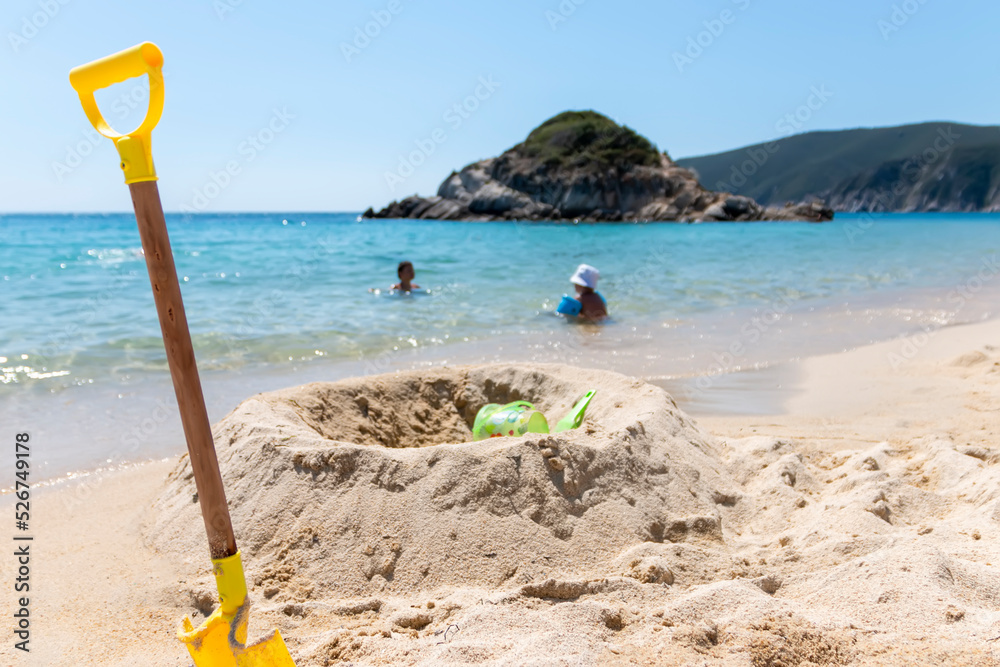 Children plastic toys using playing on sand at beach. Summer, vacation time and child development Children plastic toys using playing on sand at beach. Summer, vacation time and child development