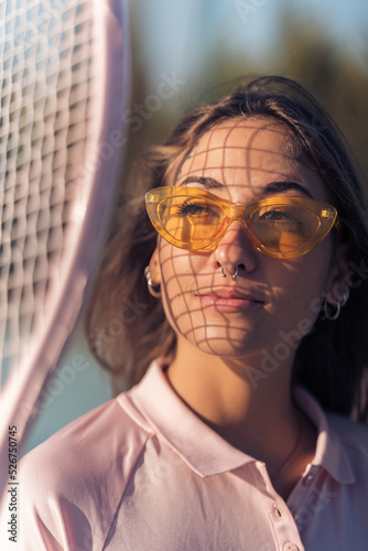 Obraz na płótnie Chica joven con septum y conjunto de tenis rosa en cancha de tenis con raqueta w salonie