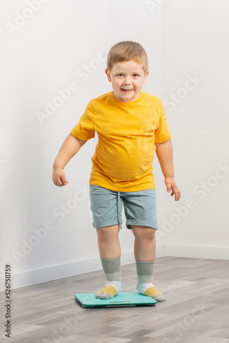 overweight little boy on scales at home