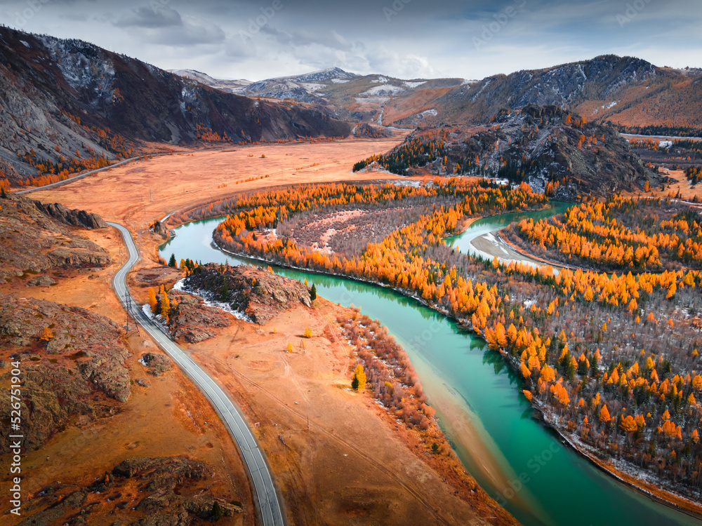 Blue river with yellow autumn trees in the mountains at sunset. Altai, Russia