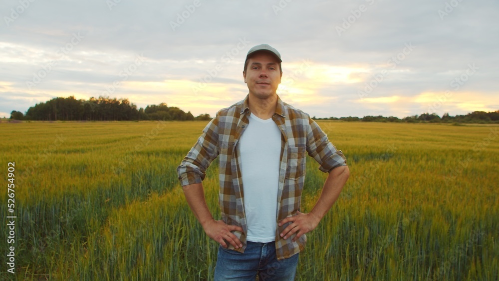 Farmer in front of a sunset agricultural landscape. Man in a countryside field. Country life, food production, farming and country lifestyle. Farmer in front of a sunset agricultural landscape. Man in a countryside field. Country life, food production, farming and country lifestyle.
