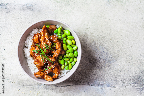 Foto Teriyaki chicken with rice and edamame beans in gray bowl