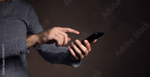 man holding smart phone on dark background