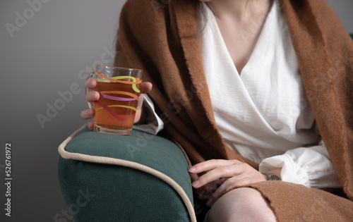 Women hands hold a hot tea sitting on sofa