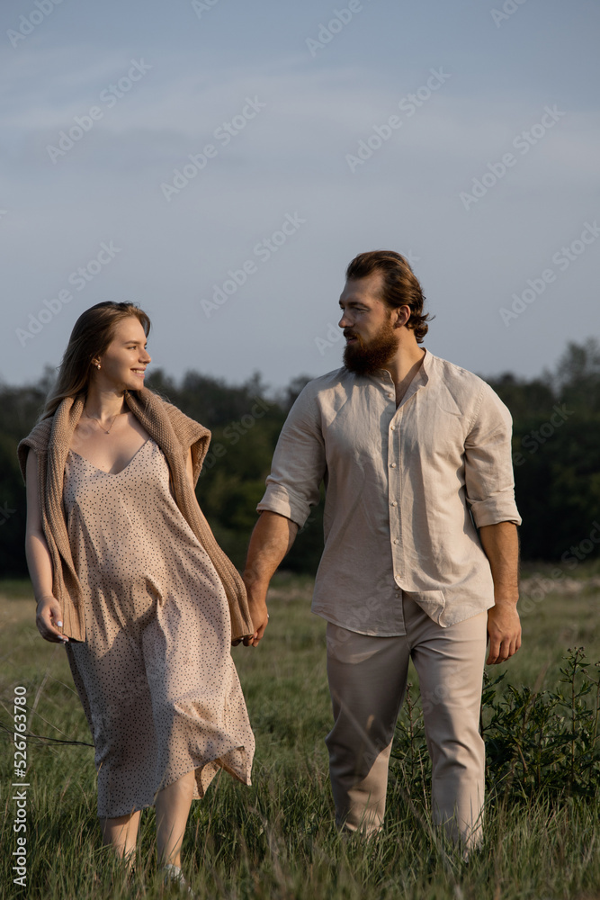 young married couple walking in the park in beige clothes young married couple walking in the park in beige clothes