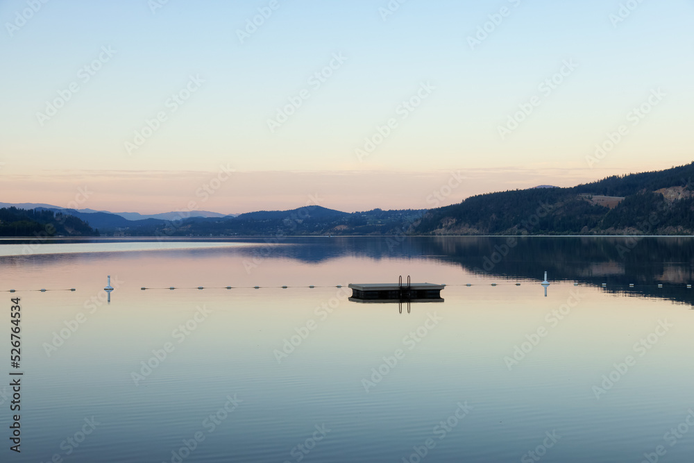 Peaceful View of Wood Lake with Reflection on the water and mountains in background. Lake Country, Okanagan, British Columbia, Canada. Sunrise