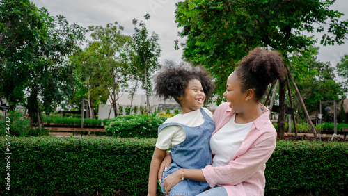 Beautiful african american mother and daughter smiling happy and hugging. Standing with smile on face standing at the park nature.Summer Activity and happy mother day.
