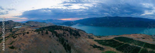 Aerial View of Canadian Landscape with Kalamalka Lake and Mountains. Colorful Cloudy Summer Sunrise. Near Vernon, Okanagan, BC, Canada. Nature Background Panorama