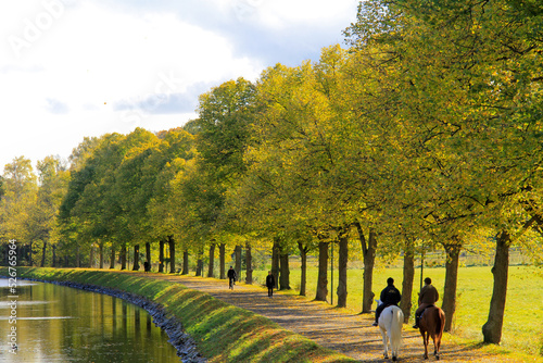 Photography Autumn landscape, people riding horses at lakeside in autumn