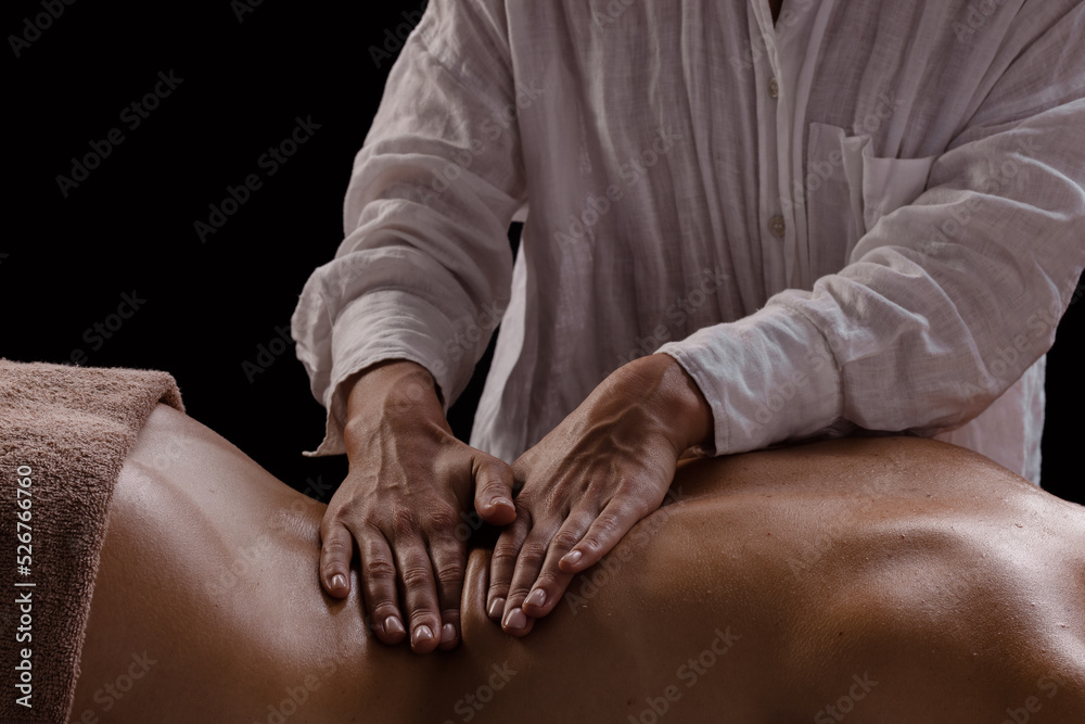 a girl makes a massage with oil close-up on a dark background