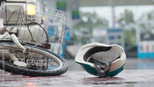 Bicycle helmet spinning and falling down bicycle on the road after traffic accident on a raining day