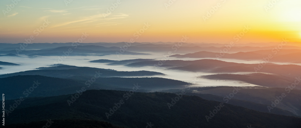 Morning fog in autumn mountains. Beautiful sunrise on background. Landscape photography panorama