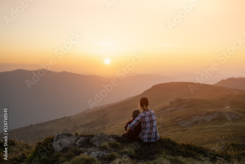 Mom with son in the autumn mountains during sunset. Travel with child concept