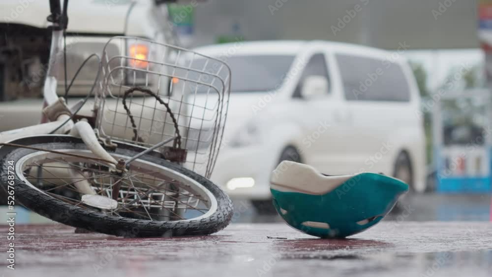 Bicycle helmet spinning and falling down bicycle on the road after traffic accident on a raining day