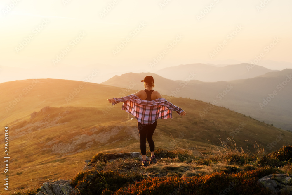 Alone girl on the mountain edge against the backdrop of an incredible autumn mountains landscape