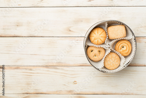 Tasty cookies in tin on wooden background, top view