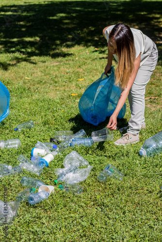 Fotografie Portrait of a young asian woman collecting plastic bottles in a park for recycli