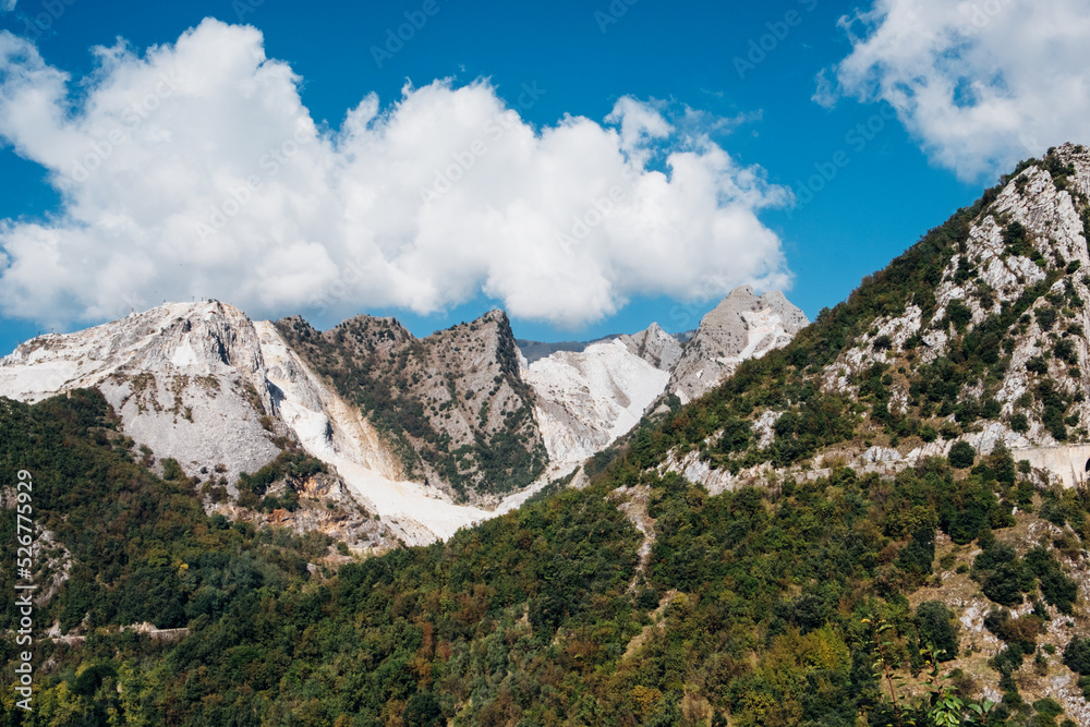 Marble quarry in Carrara, in Tuscany region, Italy. Famous industry location and place of interest. Mountain view with white marble rock and blue sky.