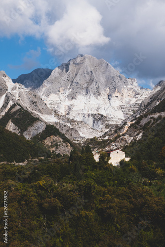 Marble quarry in Carrara, in Tuscany region, Italy. Famous location and place of interest. Mountain view with white marble rock and blue sky.
