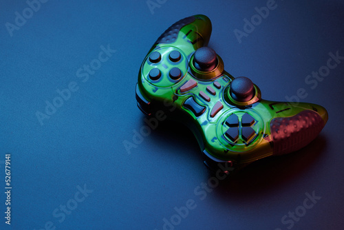 Green video game controller, joystick for game console isolated on black background. Gamer control device close-up