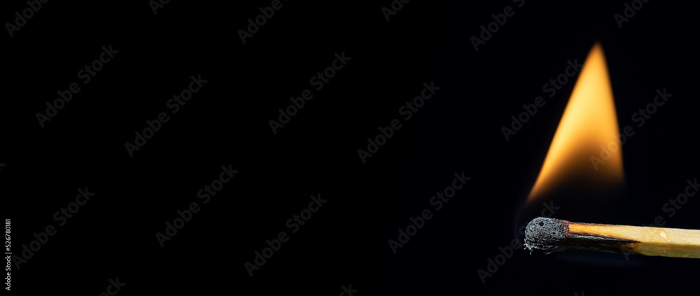 Match burning after being lit showing flame against black background ...