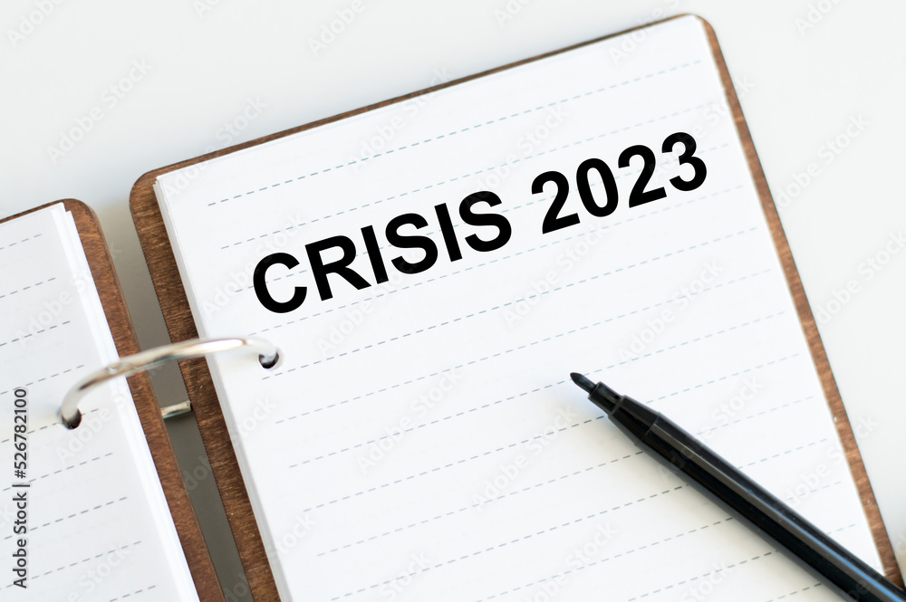 Crisis 2023 inscription on a notebook on a desk, business concept Crisis 2023 inscription on a notebook on a desk, business concept