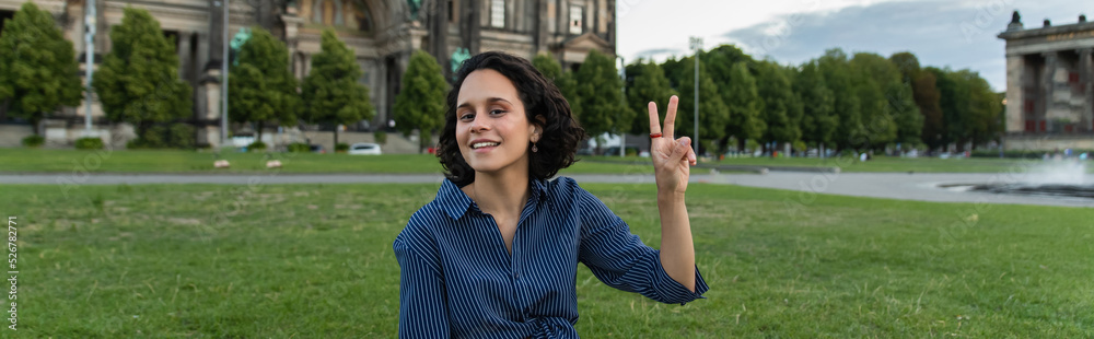 happy young woman with laptop showing peace sign in berlin, banner. happy young woman with laptop showing peace sign in berlin, banner.