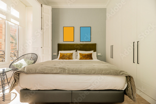 Fotografie Bedroom with double bed, headboard upholstered in green velvet fabric, matching