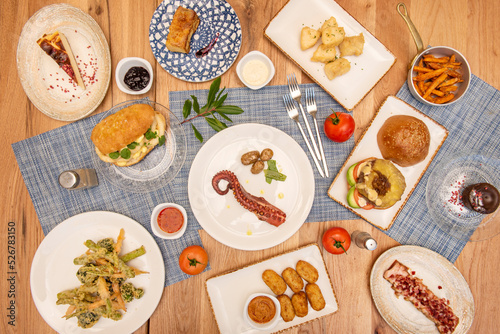Set of dishes of Spanish recipes and tapas with a modern touch, cod fritters, ham croquettes, Galician octopus, squid sandwich, odorous torrezno