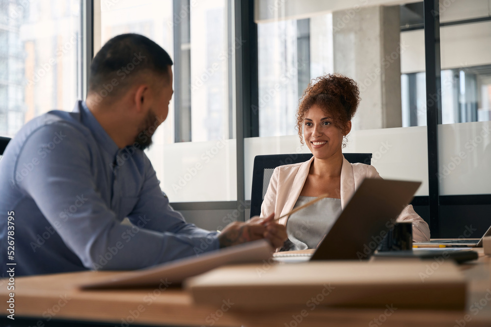 Man and woman are talking and laughing sitting at workplace Man and woman are talking and laughing sitting at workplace