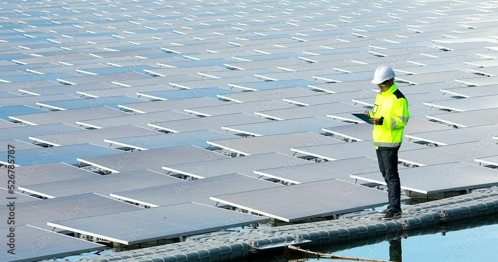 Portrait of professional man engineer working checking the panels at solar energy on buoy floating. Power plant with water, renewable energy source. Eco technology for electric power in industry.