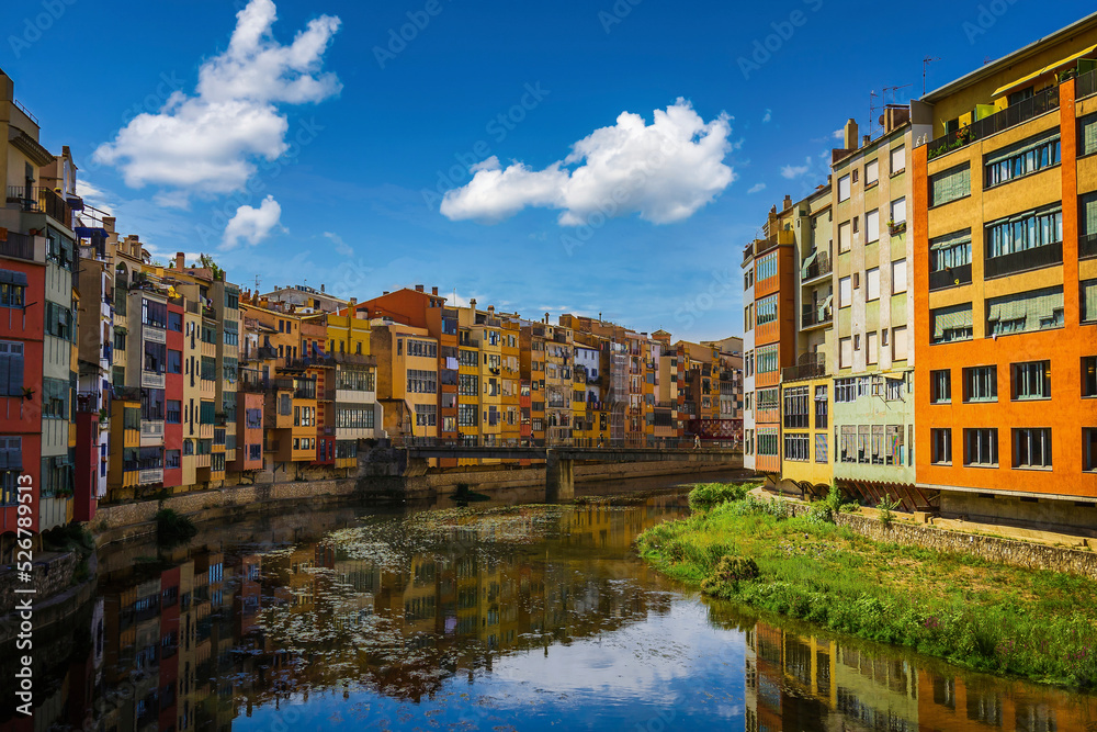 City of Girona, Spain. Buildings by the river, bridge and church tower