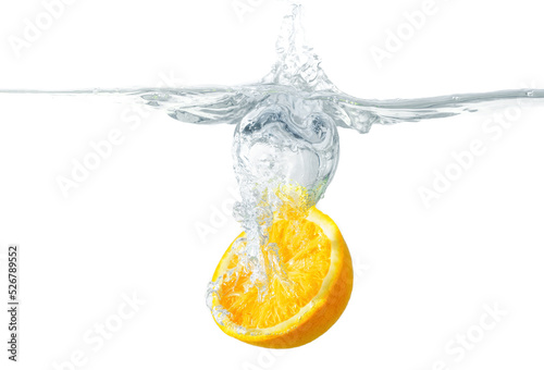 Halved orange dropped in water on white