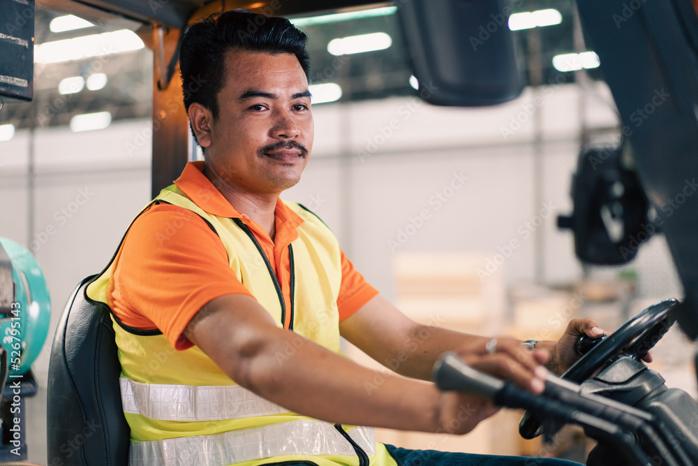 Portrait of male Asian driver driving forklift to shipping delivery in the warehouse distribution. import export logistic career, worker working at industrial factory. Portrait of male Asian driver driving forklift to shipping delivery in the warehouse distribution. import export logistic career, worker working at industrial factory.