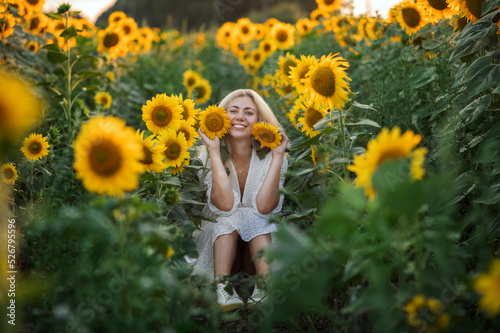 Summer evening. Girl in a field with sunflowers.