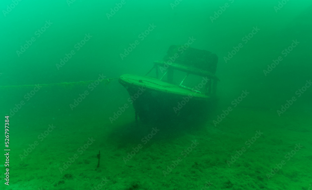Gloomy underwater wreck of recreational speed boat